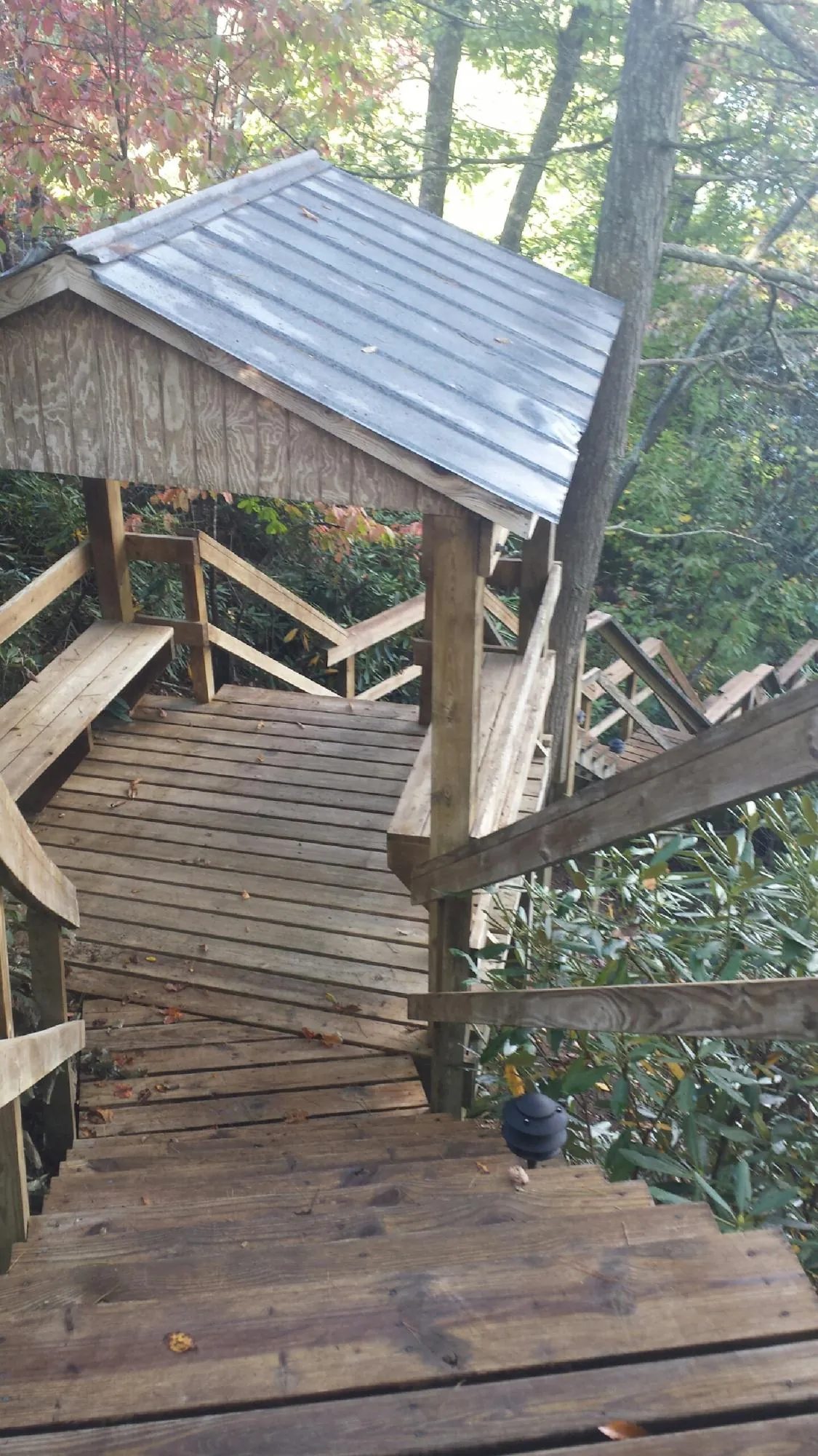 Metal roofed shelter over wooden steps on a wooded walkway — Skylight Repair & Installation work by our crew in Gloucester