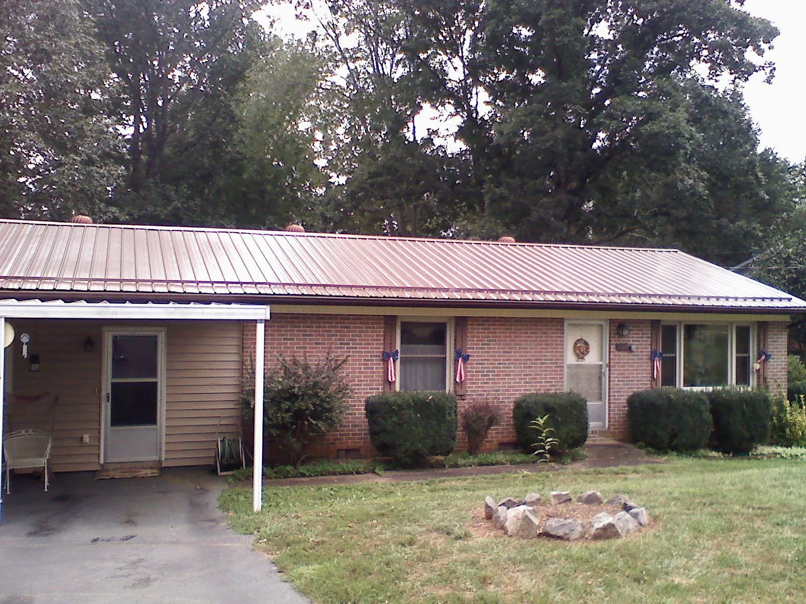 Bronze metal roof and carport on a brick ranch home — Roof Repair work by our crew in Gloucester